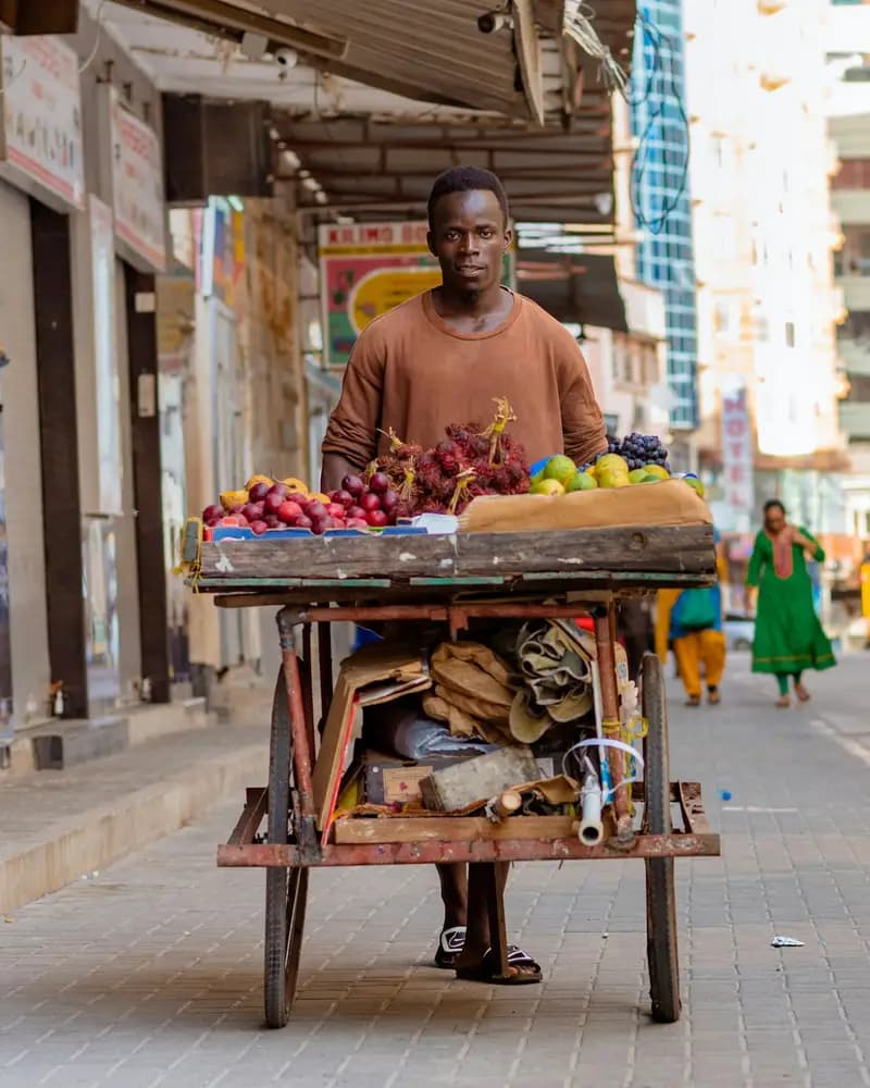 Muuza matunda akisukuma mkokoteni wake mtaani Dar es Salaam